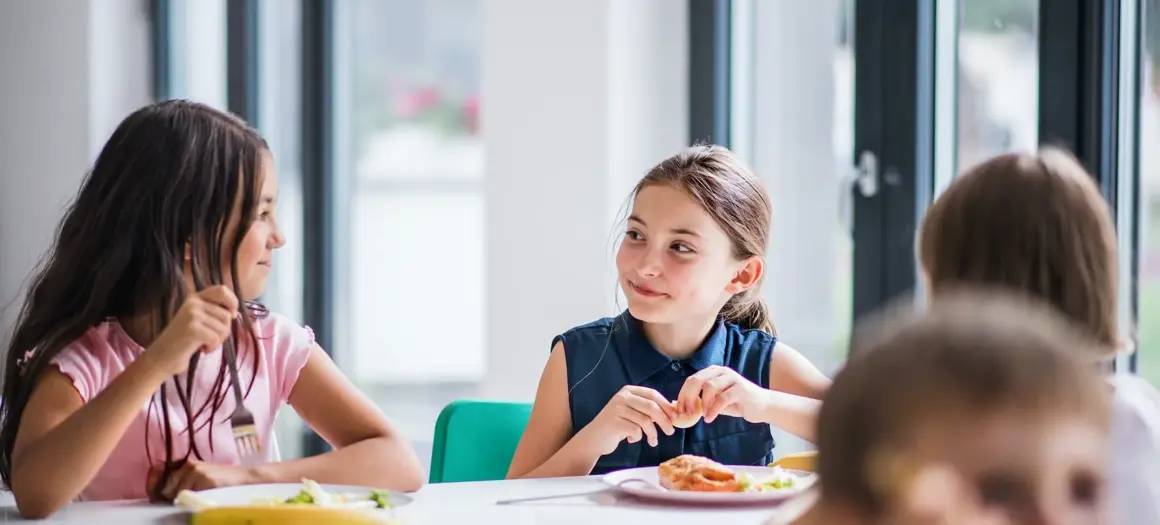Twee kinderen die eten aan tafel 