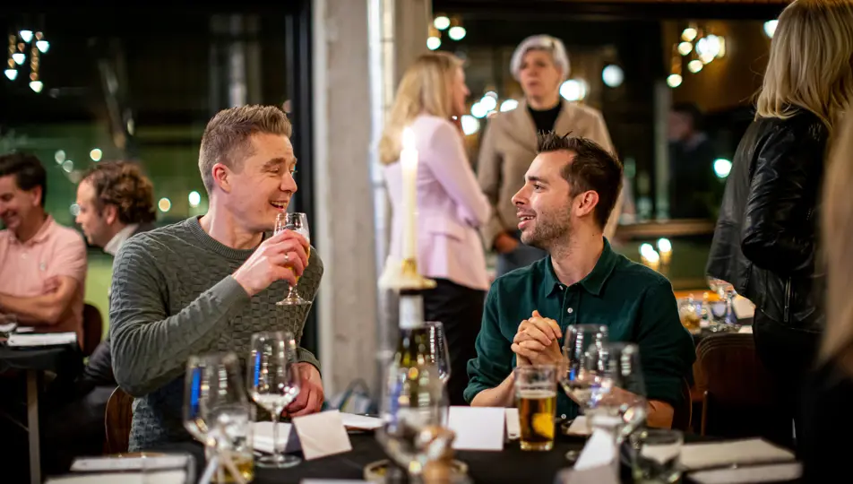 Twee aanwezigen in gesprek ronde tafeldiner