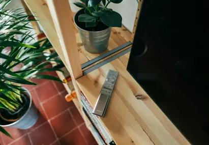 afstandsbediening op kastje naast de televisie