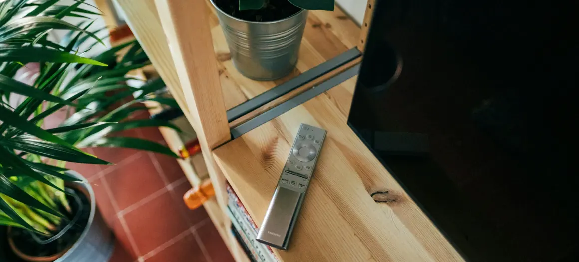 afstandsbediening op kastje naast de televisie