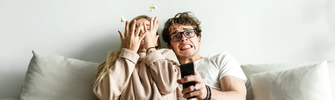 Man en vrouw kijken tv met popcorn en afstandsbediening