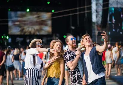 Vrolijke groep jongeren maakt een selfie op een zomers festival vol muziek, energie en merkbeleving