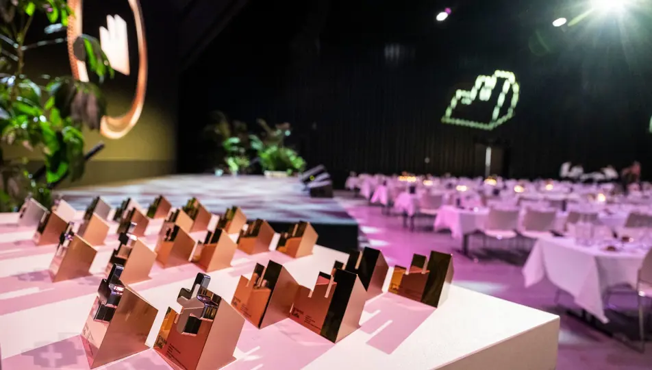 Tafel met alle effie awards erop gezet en op de achtergrond lege gedekte tafels
