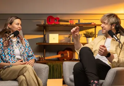 Man en vrouw praten met elkaar in een podcast setting