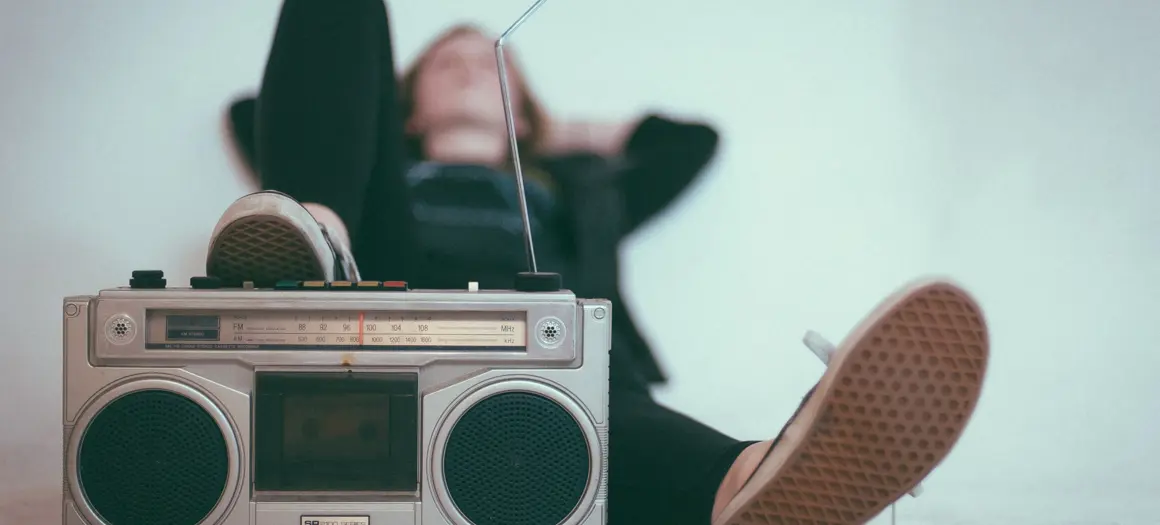 Vrouw die met haar voet leunt op radio