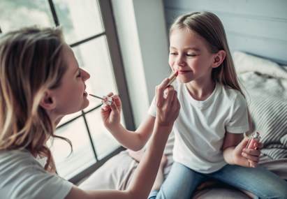 Moeder en dochter brengen make-up aan – illustratie van hoe jonge kinderen in aanraking komen met beauty en skincare