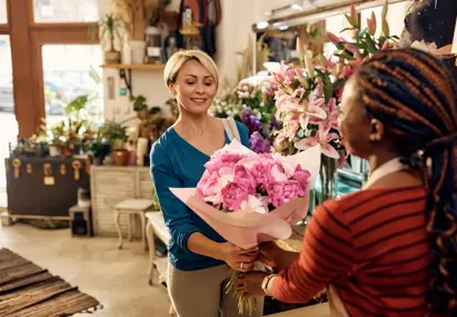Vrouw koopt boeken met roze bloemen in winkel