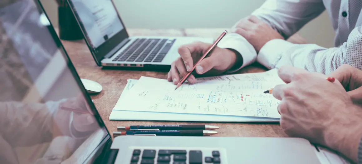 twee laptops en mensen die data bespreken