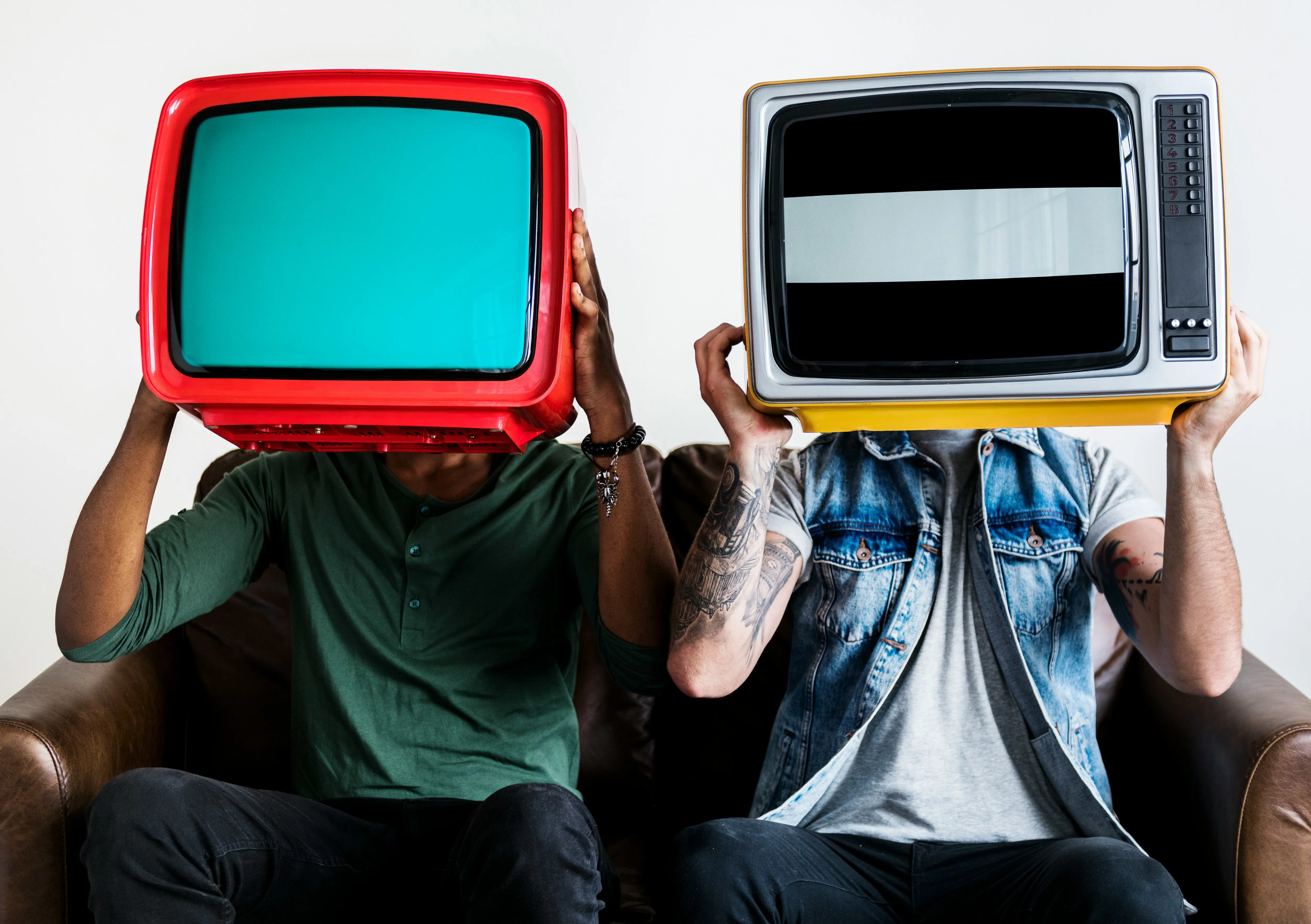 Twee mannen op bank houden beiden een ouderwetse tv voor hun gezicht 