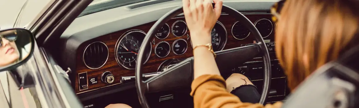 Vrouw achter het stuur in ouderwetse auto met radio